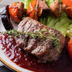 Grilled beef steak ribeye medium rare  with grilled vegetables on a plate.