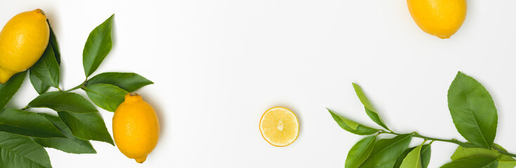 fresh, juicy, yellow lemons with green twigs lie on a white background
