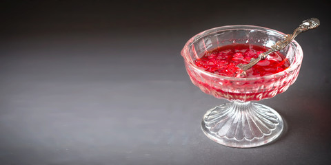 A glass vase with delicious bright translucent redcurrant jam