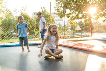 Group of children jump on trampoline in the park