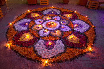 mandala of flowers with burning candles in the evening on the floor of the festival Diwali