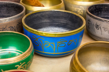 Tibetan Buddhist colored musical bowls. The inscriptions on the bowls, the mantra (om mani padme hum) , the literal translation of (Pearl in the lotus kingdom)
