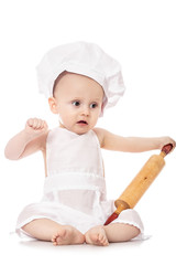 Infant cook baby in the cook costume and chef hat with dough rolling pin, isolated on a white background