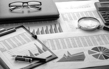 Financial documents - graphics, statistics, drawings, keyboard, laptop, magnifying glass in the...