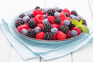 Fresh raspberries in a plate on a  vintage background.