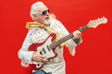 Senior guitarist playing his favorite rock'n'roll song - Old dressed up man who enjoys playing the...