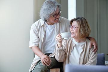 Happy family, Senior couple embracing and teasing while drink a coffee.