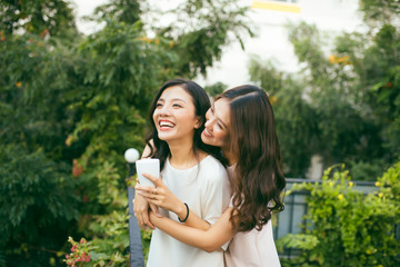 Obraz premium Two Women Relaxing On Rooftop Garden Drinking Coffee