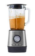 Stationary blender with cooked smoothie made from apples, pumpkins, strawberries and greens.