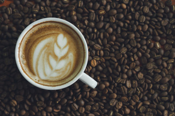 white coffee mug.  Coffee is a latte. table on the wooden table in vintage style, taken from the top view, see the froth of milk foam.