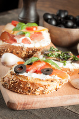 Italian tomato and cheese bruschetta. Tapas, antipasti with chopped vegetables, herbs and oil on grilled ciabatta and baguette bread.