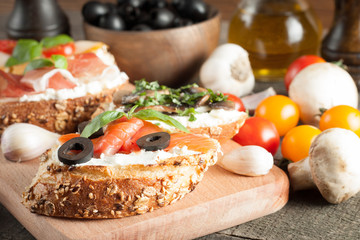 Italian tomato and cheese bruschetta. Tapas, antipasti with chopped vegetables, herbs and oil on grilled ciabatta and baguette bread.