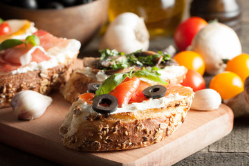 Italian tomato and cheese bruschetta. Tapas, antipasti with chopped vegetables, herbs and oil on grilled ciabatta and baguette bread.