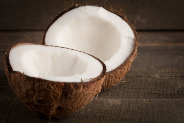 Ripe half cut coconut on a wooden background. Coconut cream and oil.