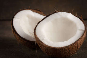 Ripe half cut coconut on a wooden background. Coconut cream and oil.