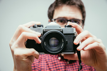 Young man is taking a picture with a vintage camera