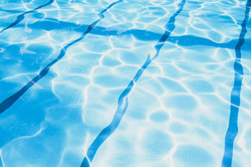 Fototapeta premium Summer day at swimming pool. Background and texture concept. Ripple Water in swimming pool with sun reflection