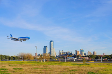 Airplane landing in Buenos Aires at the city airport, skyscrapers of Puerto Madero in the...