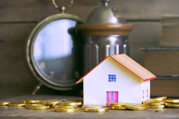 House model and gold coin stack on the table