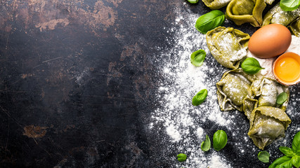 fresh basil tortellini with ingredients on a dark underground