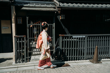 side view of local japanese female people in traditional kimono cloth walking on road. full length...