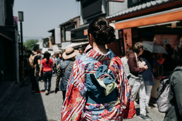 back view of japanese young girl in flower kimono dress walking in kiyomizu zaka street. woman join...