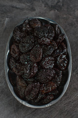 Rustic plate with  tasty smoked dried plums on table