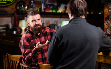 Friday relaxation in bar. Friends relaxing in bar or pub. Interesting conversation. Hipster brutal bearded man spend leisure with friend at bar counter. Men relaxing at bar. Friendship and leisure