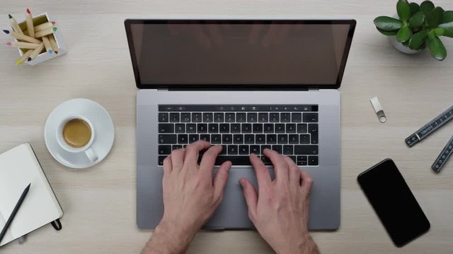 Male hands typing laptop on white clean minimalistic table with top view, gestures and finger movements