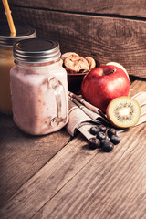 Obraz na płótnie Canvas Smoothie in glass jar on rustik wood. Healthy beverage and fresh fruit