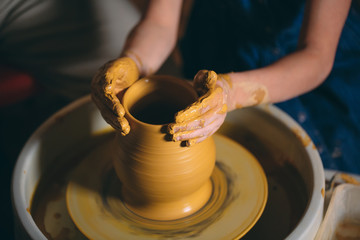 Pottery workshop. A little girl makes a vase of clay. Clay modeling