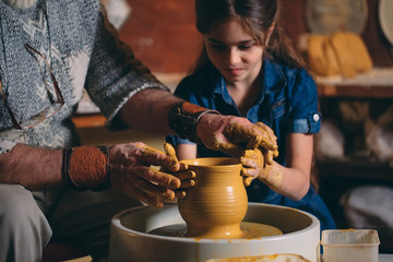 Pottery workshop. Grandpa teaches granddaughter pottery. Clay modeling