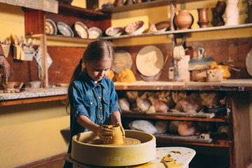 Pottery workshop. A little girl makes a vase of clay. Clay modeling