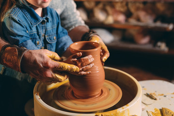 Pottery workshop. Grandpa teaches granddaughter pottery. Clay modeling