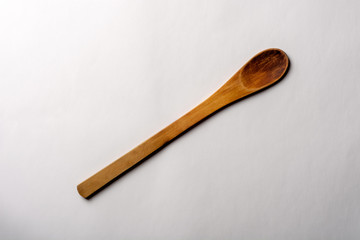 Vintage Wooden Spoon on White Textured Paper. Kitchen and Cooking Concept.