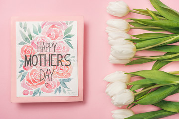 happy mothers day greeting card and white tulips on pink background