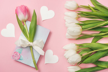 pink tulip with white bow on greeting card, paper hearts and white tulips on pink background