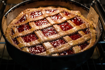 Linzer torte (christmas almond pastry with lattice design) coming out of the oven after being baked.