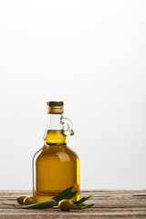 bottle of with olive tree leaves and olives  isolated on grey