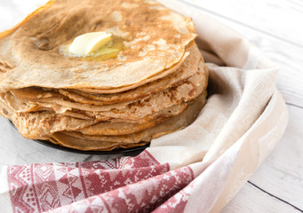 lots of pancakes on a plate, pancakes with butter, towel