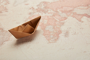 paper boat on vintage world map