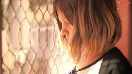 Sad cute 8 year old girl child looking outside, thinking. Closeup, slow motion, 4K UHD.