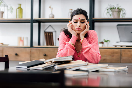 Sad Indian Student With Bindi Studying At Home With Books