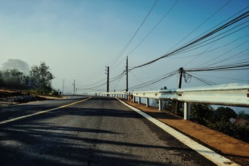 Obraz na płótnie Canvas dreamy road among foggy pine forest