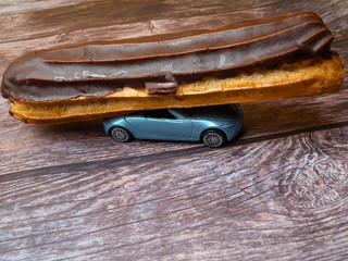 Eclair with chocolate fudge on a car, eclair delivery concept