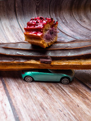 Eclair with chocolate fudge on a car, eclair delivery concept
