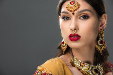 attractive indian woman posing in traditional bindi, isolated on grey