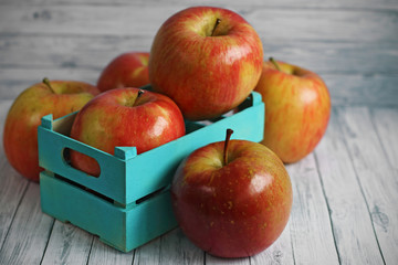 Fresh red apples on white wooden background