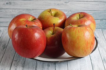 Fresh red apples on white wooden background