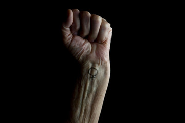 Female hand clenched into a fist with a female symbol on the wrist
